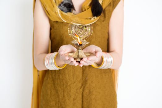 Fair Indian woman in traditional dress hands holding diya oil lamp and celebrating Diwali or deepavali, fesitval of lights.