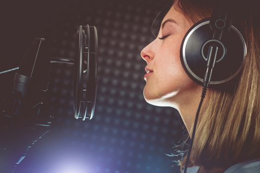 Music Passionate Singer and the Microphone. Young Caucasian Singer in Her 20s Recording Album in the Professional Studio. Singing with Passion.