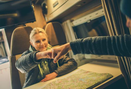 Approved RV Trip Fist Bump. Happy Couples in the Camper Motorhome Planning New Road For the Next Day Trip.