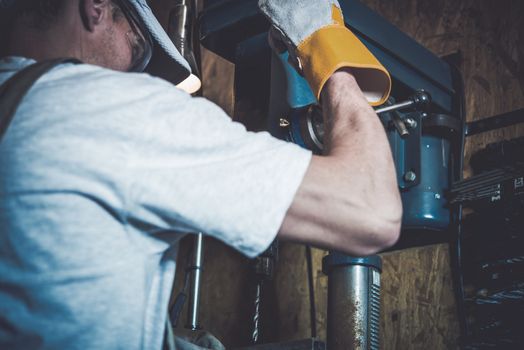 Garage Metal Works. Men and the Professional Grade Driller in His Garage.