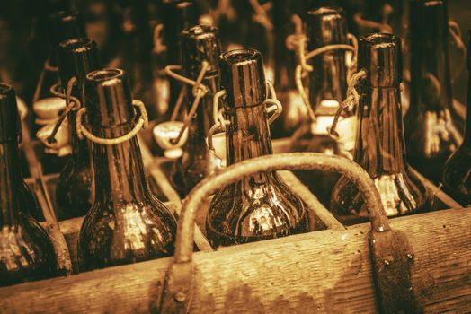 Old Drink Bottles in the Wooden Crate. Vintage Glass Bottles. Sepia Color Grading.