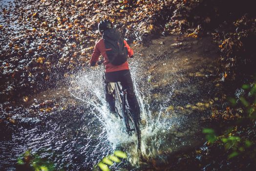 Bike Mountain River Crossing at High Speed with Splashing Water. Mountain Biker.