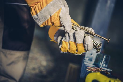 Choosing Right Screws. Construction Worker with Screws in Hands