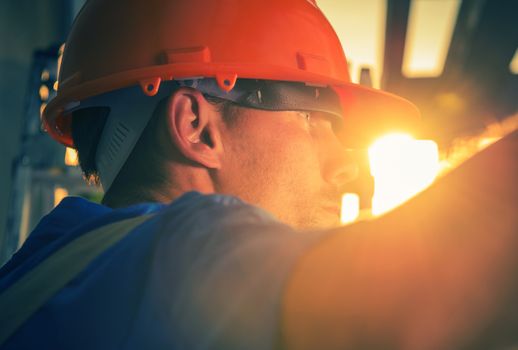 Construction Worker in the Sun. Caucasian Worker in His 30s Wearing Red Safety Helmet.