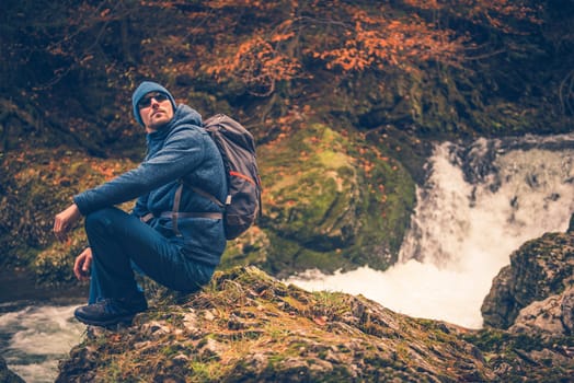 Fall Time Hiking. Autumn Foliage and the Hiker Resting on the River Creek Boulder