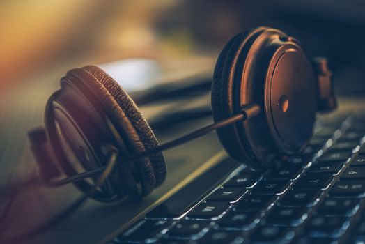Online Digital Music Headphones and the Laptop Computer. Professional Headphones on the Computer Keyboard.