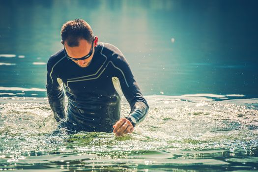 Wetsuit Water Sports. Caucasian Sportsman in the Black Wetsuit.