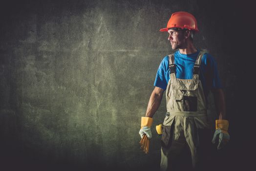 Caucasian Construction Worker Portrait on the Raw Concrete Wall.