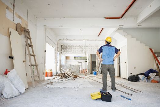 House improvement concept. Rear view of Asian construction worker looking away.