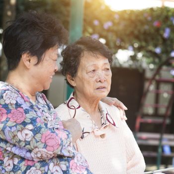 Candid shot of Asian senior adult women chatting at outdoor park in the morning.