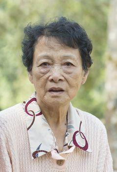 Portrait of Asian elderly woman at outdoor garden park in the morning.
