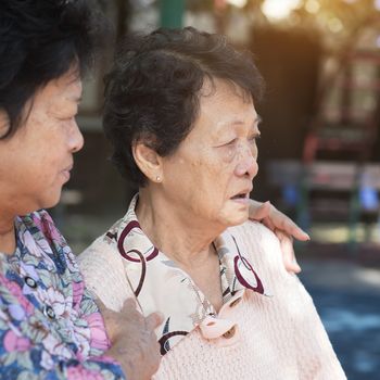Candid shot of Asian senior adult women chit chatting at outdoor park in the morning.