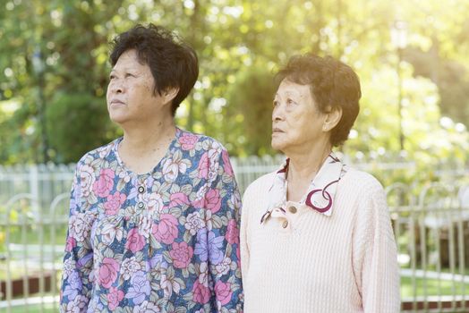 Candid shot of Asian elderly women walking at outdoor garden park in the morning.