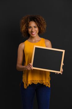 Beautiful African American woman showing something on a chalkboard