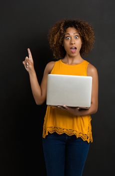 Beautiful African American woman holding and showing something on a laptop