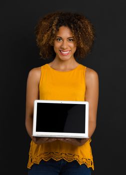 Beautiful African American woman holding and showing something on a laptop