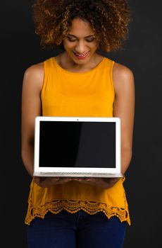 Beautiful African American woman holding and showing something on a laptop