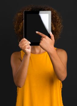 Beautiful African American woman holding and showing something on a tablet