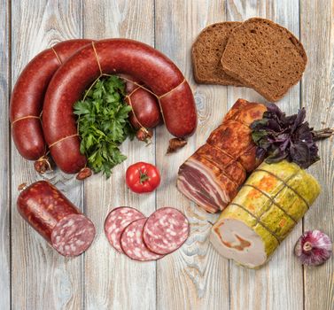 Different kinds of sausages with vegetables on a wooden table