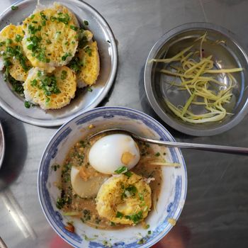 Vietnamese street food, banh can is one of pancake with egg, fish, mango, a famous Vietnam dish at Lien Huong, Binh Thuan, cake process from rice flour