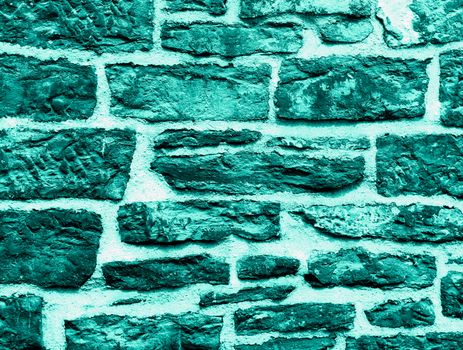 Background of Turquoise Wall Stones with Cracked Surface and Concrete closeup Outdoors