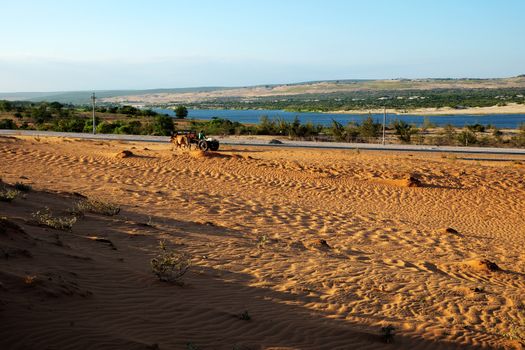 Vietnamese landscape at Bau Trang, Hoa Thang, Binh Thuan, Viet Nam. Wonderful place for travel in summer, people ride wagon moving on sand hill, lake among dry land make nice scene