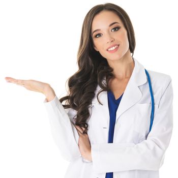 Happy smiling young beautiful female doctor showing blank area for sign or copyspace, isolated on white background