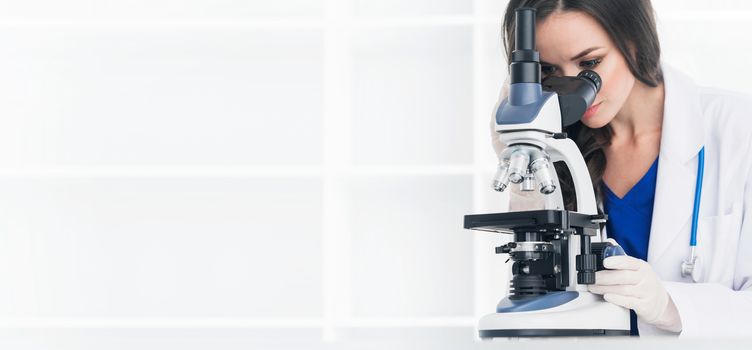 Female scientist working in a lab with microscope