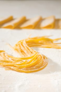 Fresh uncooked tagliatelle pasta over a table