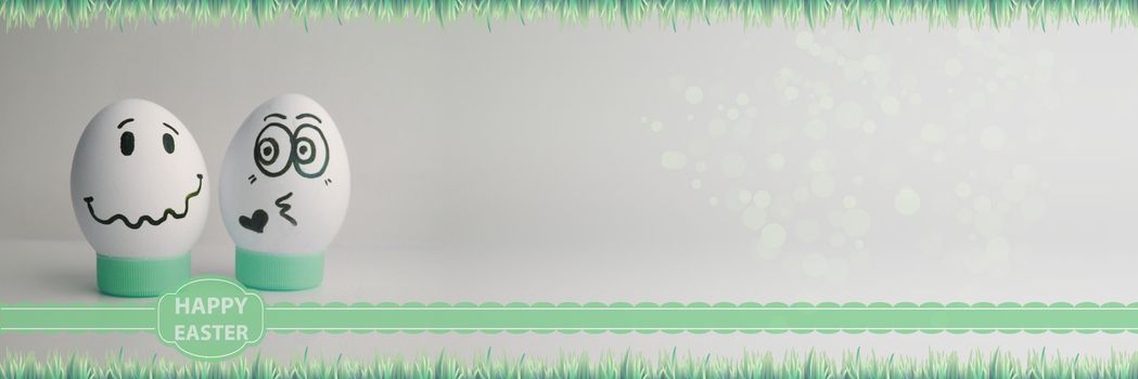 Easter eggs two pieces with faces drawn on a light background a line of grass. Photo for your design with a place under the text