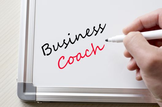 Human hand writing business coach on whiteboard