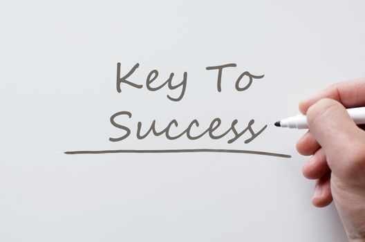 Human hand writing key to success on whiteboard