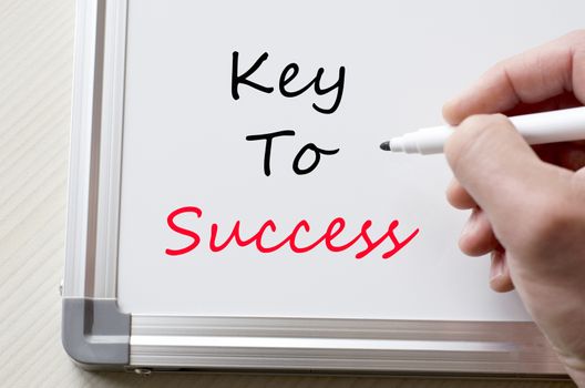 Human hand writing key to success on whiteboard