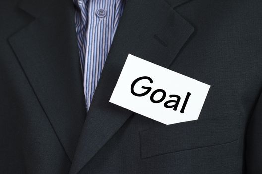 Goal text note concept over business man background