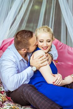 Man and woman sitting on the bed on the lawn and hugging in Lviv, Ukraine.