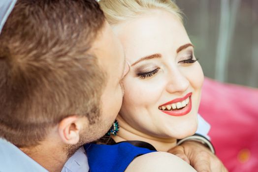 Portrait of a man and a woman sitting on the bed in the lawn and woman closed her eyes and smiling in Lviv, Ukraine.