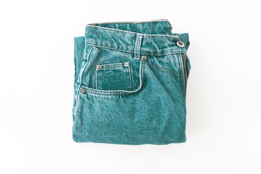 .Turquoise, green retro jeans neatly folded, isolated