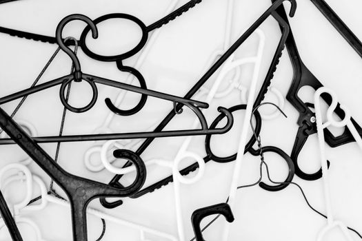 Many hangers of different shapes and colors, top view, white background.