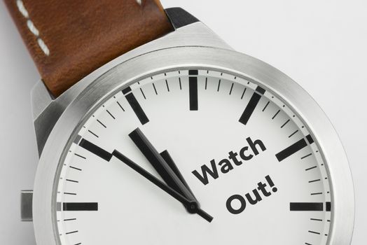 Analog watch with conceptual visualization of the text Watch Out

