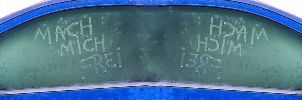 Frozen car window with a message text in German, make me free.