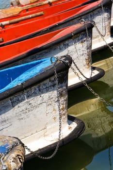 Boats waiting in the pond tied with a chain. Vertical image.