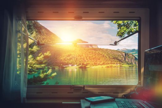 Work Desk with Scenic View. Working in the Camper Van Motorhome While Traveling During Vacation Time. Working on Laptop Inside RV Motorcoach. 