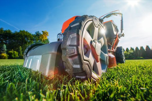 Modern Gasoline Lawn Mower on the Field. Equipment at the Backyard Garden.