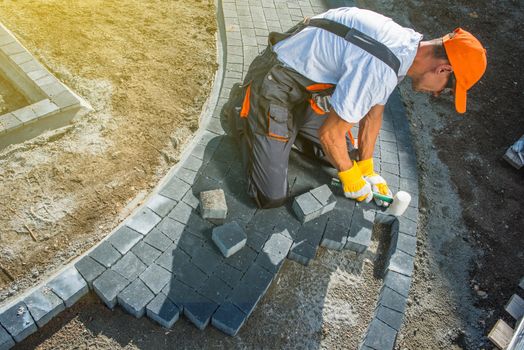 Brick Paving Works. Professional Caucasian Worker Building Block Paved Hardstanding Garden Path