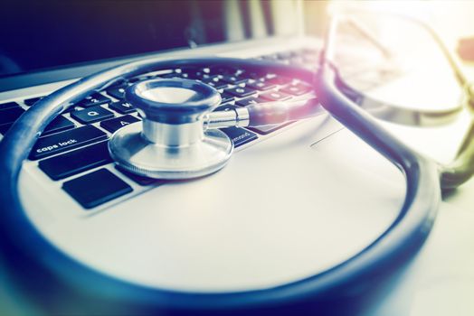 Doctors Clinic Computer and Stethoscope Closeup Photo. Computers in Health Care Concept.