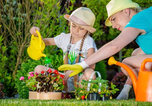 Mother and Daughter Working in Backyard Garden. Girl Learning How to Take Care of Garden Plants. Taking Care of Backyard Garden.