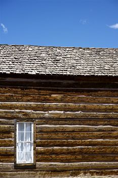 Vintage Building - Very Old Colorado Log House with Small Window. Vertical Photography. Colorado U.S.A.