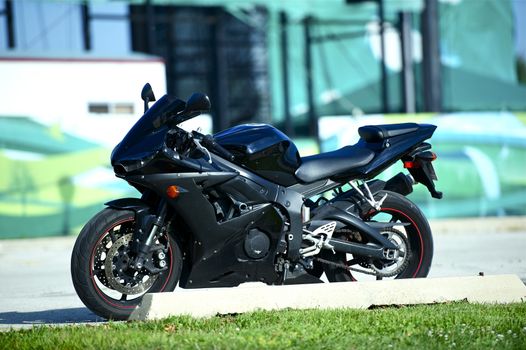 Black Sportbike Parked on the Street. Fast Sporty Looking Motorcycle. Horizontal Photo.