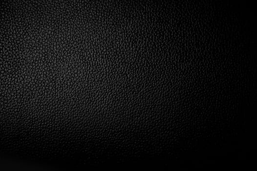 Black Plastic Background - Horizontal Studio Photo. Partially Illuminated.
