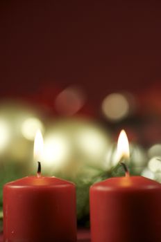 Two Red Candles with Bokeh. Christmas Ornaments in the Bokeh Background